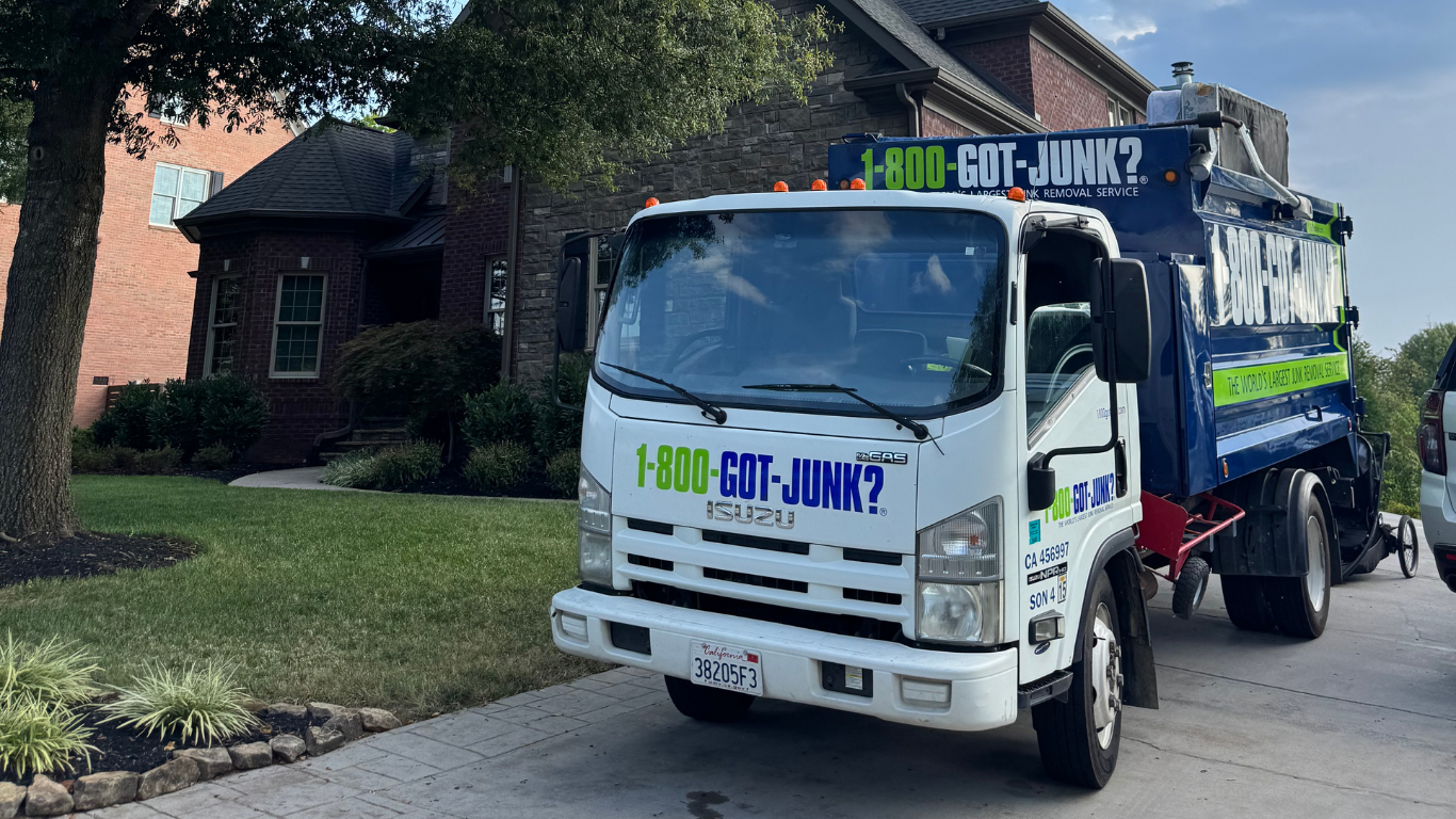 1-800-GOT-JUNK? truck in front of a house.