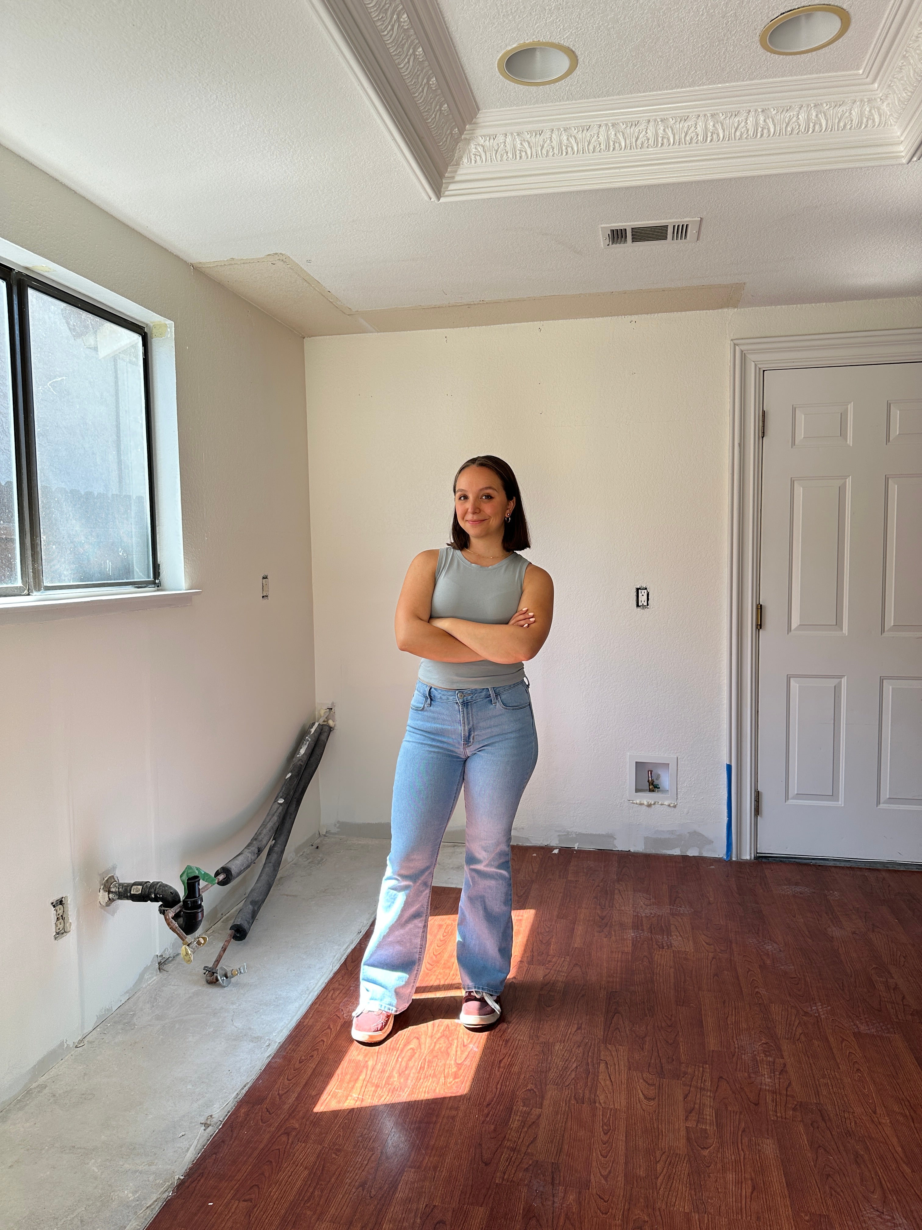 Person standing in a newly prepped kitchen space in Antioch, CA, with freshly painted walls post-demolition.