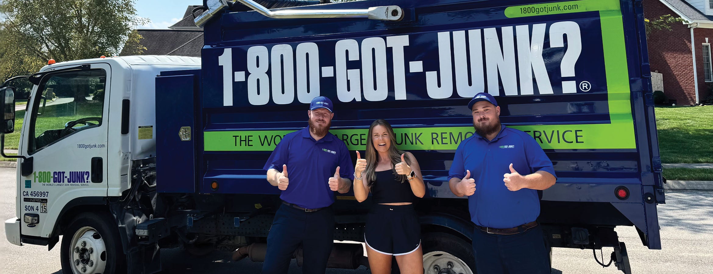 Laura Elizabeth Graham with two 1-800-GOT-JUNK? Truck Team Members in front of a 1-800-GOT-JUNK?