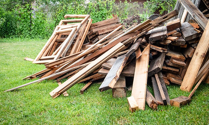 Different types of treated lumber and untreated wood at a recycling facility.