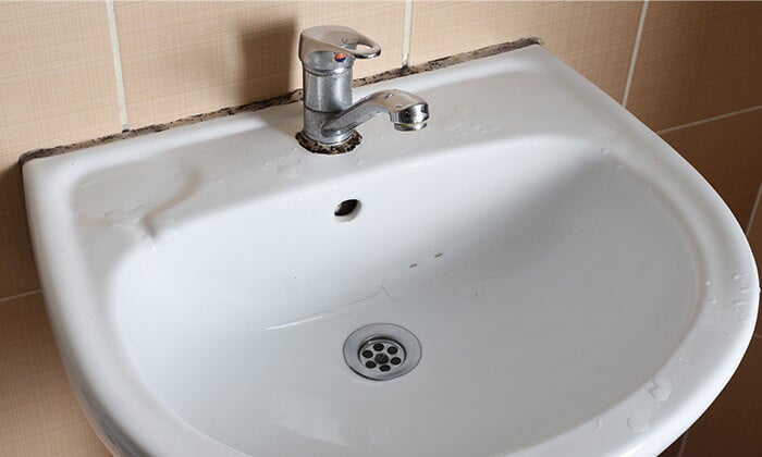 An old bathroom sink ready to be disposed.